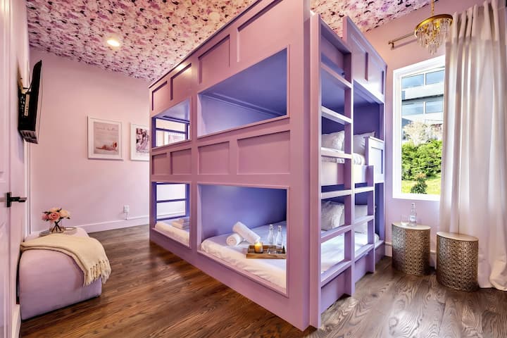 Step into this stylish bedroom featuring bunk beds perfect for your Nashville getaway! Relax in comfy linens and soak in the vibrant decor. Ideal for large groups or bachelorette parties. Experience luxury at Misfit Homes and reserve your stay today