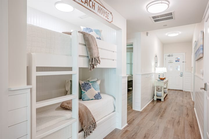 Twin XL over Twin XL bunk beds located in the entry hall. Sturdy, comfortable setup with plenty of room for smaller adults or kids, and easy access to the hallway and shared bathroom.