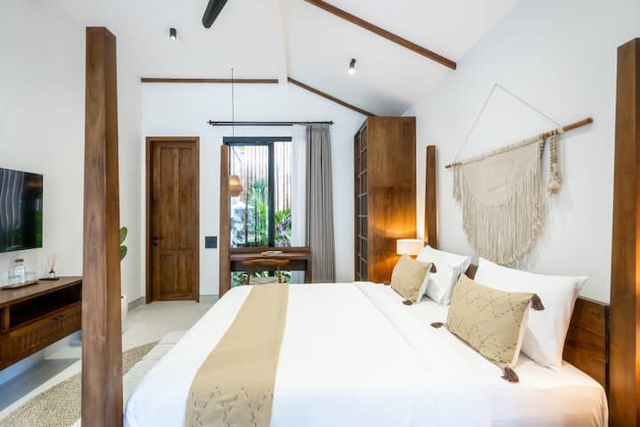 這間迷人的臥室配有舒適的四柱牀、溫暖的木質裝飾，以及從大窗戶欣賞花園景觀的充足自然光線。