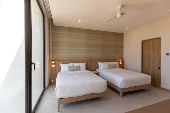 Encuentra comodidad y comodidad con dos camas tamaño queen en el segundo dormitorio del condominio Batimetria en Become Nosara