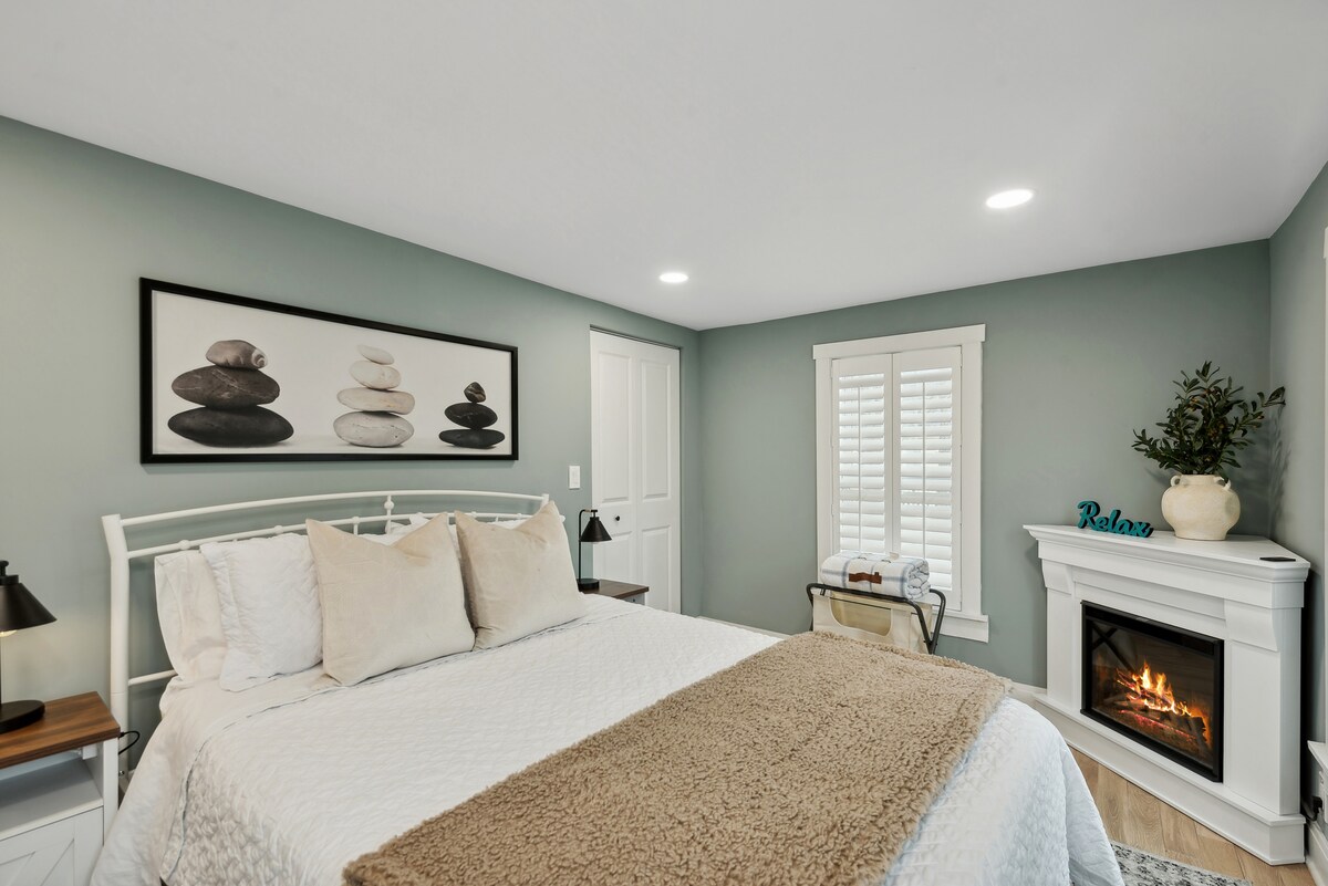 غرفة نوم بحجم كوين مع مدفأة داخل الغرفة ومصاريع مزارع وخزانة كبيرة