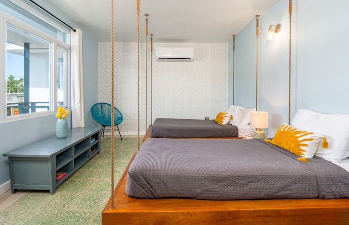 Dormitorio divertido en Rincón, Puerto Rico: camas suspendidas, colores tropicales y diseño alegre para estadías inolvidables en la isla.