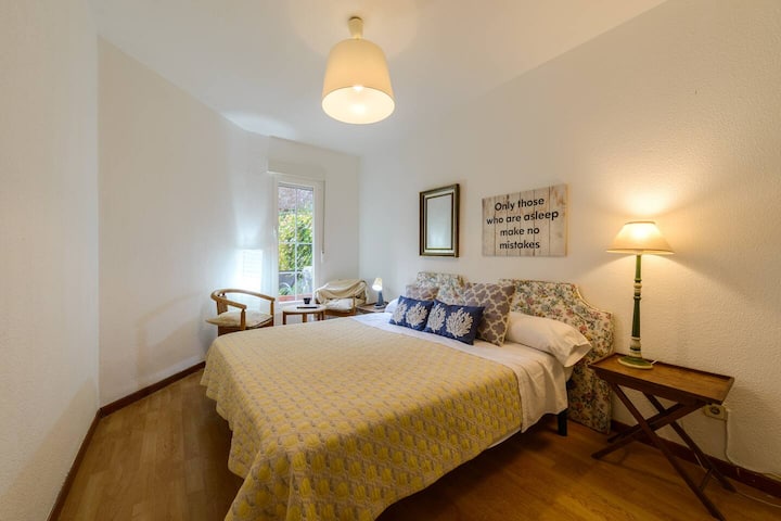 Dormitorio con cama de matrimonio y colcha amarilla: luz cálida para un descanso reparador.