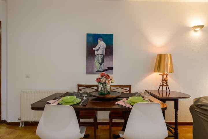 Comedor con mesa redonda y sillas blancas: espacio recogido para desayunar sin prisa.