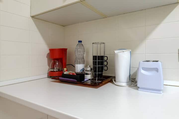 Detalle de la encimera con cafetera, hervidor y tostadora: desayunos resueltos en un minuto.