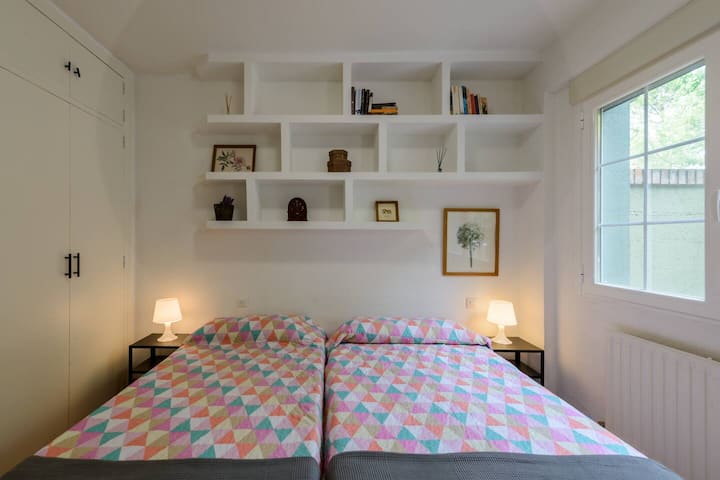 Dormitorio con dos camas individuales y almacenaje.