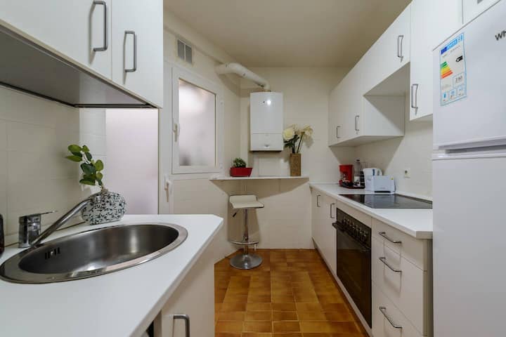 Cocina independiente con fregadero, horno y barra con taburete: todo a mano para cocinar cada día.