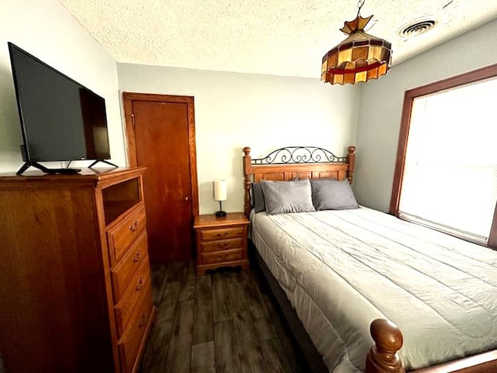 Queen bedroom with lamp and plenty of charging ports