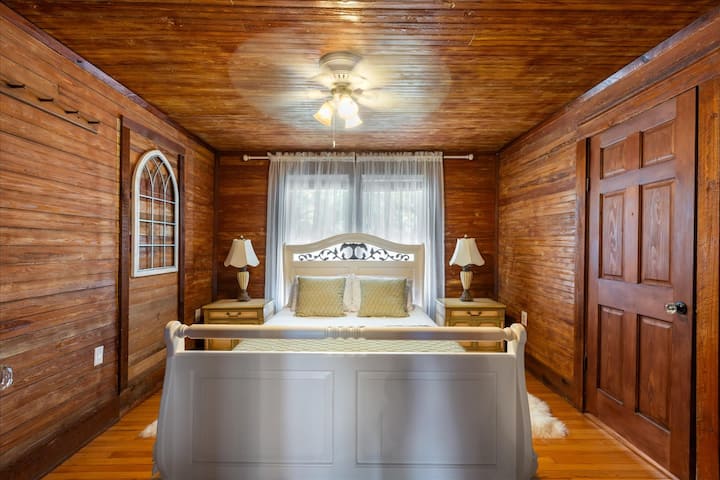 غرفة نوم كوين 2: مغمورة بأشعة الشمس وهادئة. تسمح النوافذ الكبيرة ذات الستائر الشفافة الناعمة بدخول وهج الصباح المثالي، بينما تضمن مروحة السقف العلوية راحة ليلية باردة ومريحة.