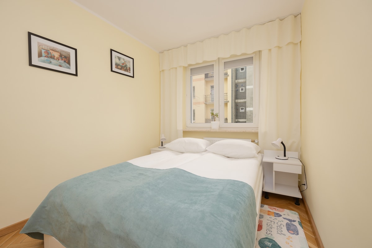 Habitación llena de luz con ropa de cama suave y un espacio de trabajo.

