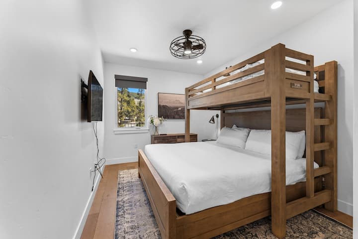 Guest bedroom with twin over king bunk bed and mounted smart TV. 