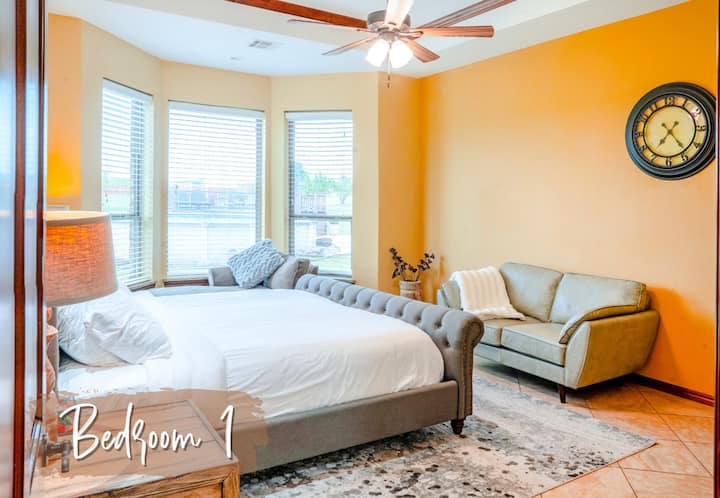 מיטת קינג סייז, ראש מיטה מרופד, מאוורר תקרה, חלונות מפרץ עם תריסים, יצירות אמנות בטבע, שידות ליד המיטה עם מנורות, כורסה, שמיכה