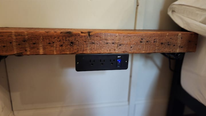 The Spa View and Porch View bedrooms boast bedside tables made from old barnwood, each featuring a multi-charging unit on either side of the bed for your convenience.