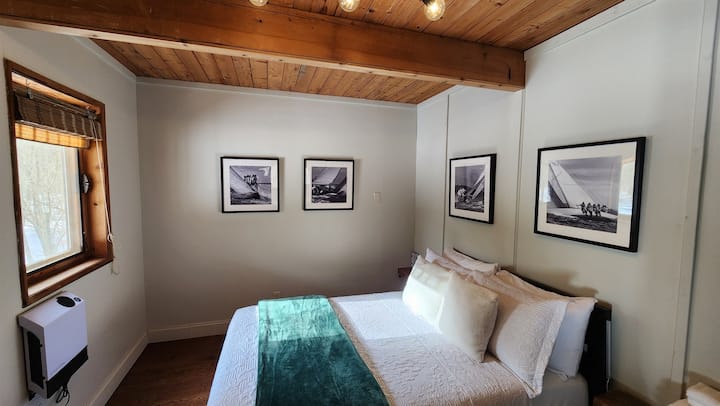 Stay in the Porch View Bedroom on the first floor, featuring a comfy full bed and a wide doorway for accessibility. Enjoy easy access and beautiful views for a restful and convenient stay.