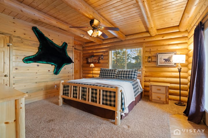 Ფართო საძინებელი ლუქს-კლასის დიდი ზომის საწოლით, რომელიც გამოწყობილია რბილ თეთრეულში კომფორტული დასვენებისთვის.