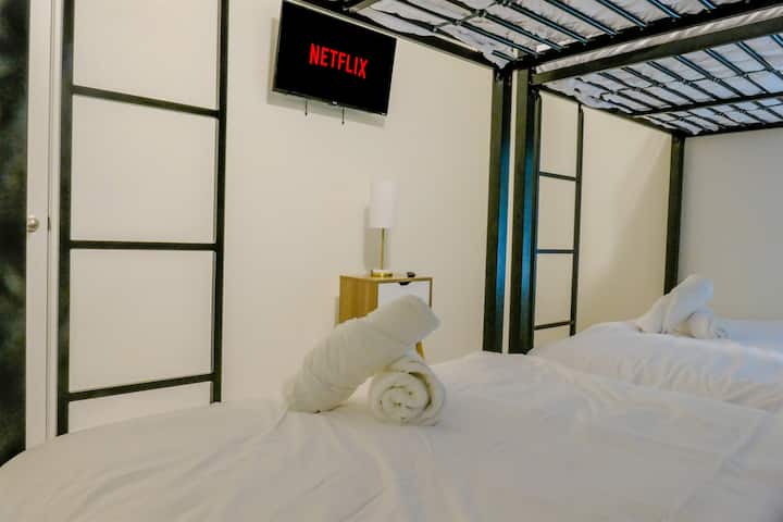 Doživite utjelovljenje moderne udobnosti u ovoj dobro osvijetljenoj sobi. S dva udobna kreveta na kat, televizorom, elegantnim noćnim ormarićem i elegantnom svjetiljkom, ovaj vas prostor poziva da se opustite i opustite.