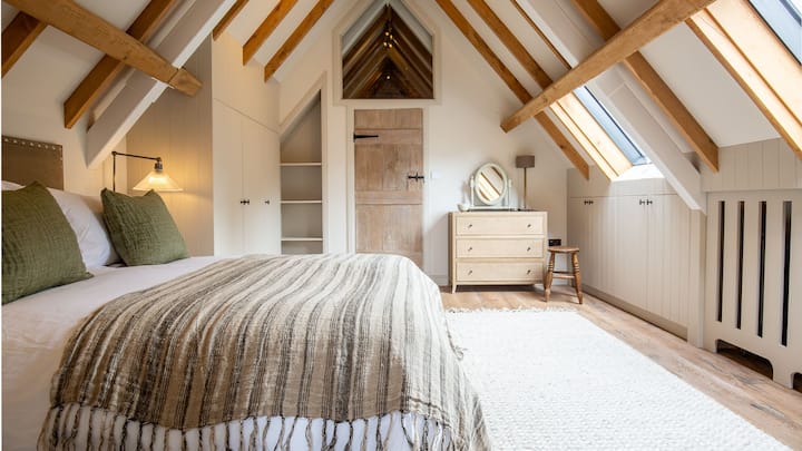 Მწვრთნელის სახლში მეორე საძინებელში არის დიდი ზომის საწოლი, რომელიც ზის A ‑ სებრი კოჭების ქვეშ