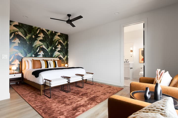 (Segundo piso) Cuarto dormitorio con cama tamaño king, zona de estar adicional, decoración de diseño y baño privado.