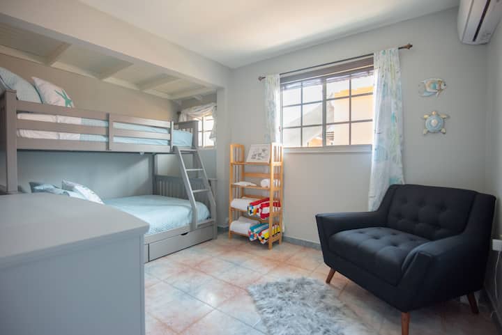 Organized kids' room featuring bunk beds and a cozy seating area.