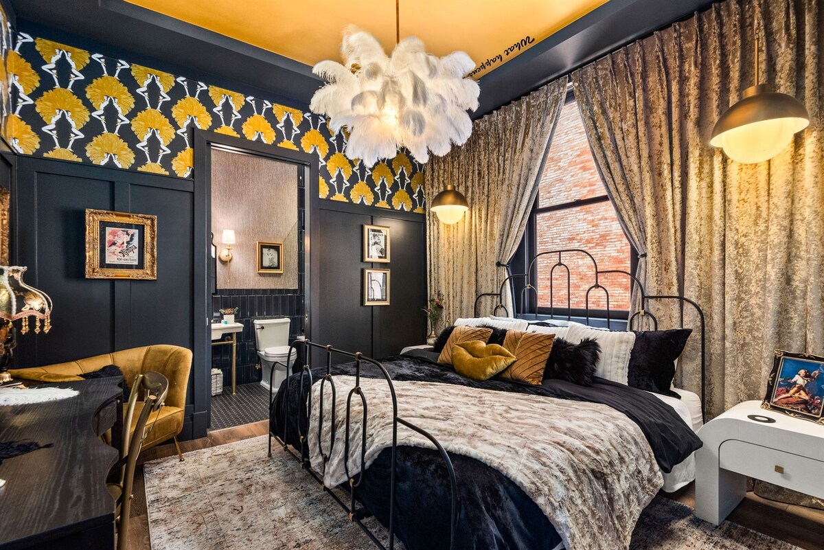 - Bedroom with yellow accents, soft textures and dramatic lighting   - Floral wallpaper and warm tones create a cozy retreat   - Inviting setup offering comfort, charm and standout design
