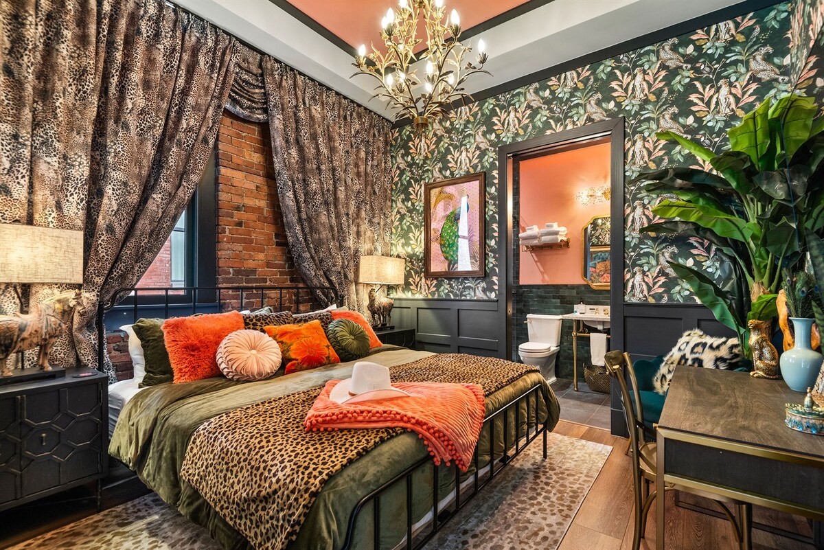 - Lush bedroom with botanical wallpaper and warm patterned décor   - Plush bedding blends with bold textures and soft lighting   - Cozy escape offering vibrant style and inviting comfort