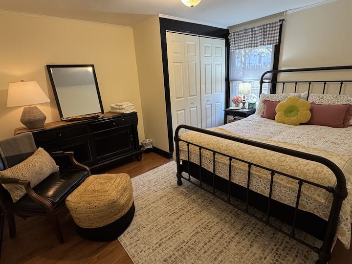 Оваа пространа брачна спална соба има гардеробер, простор за седење и голем плакар