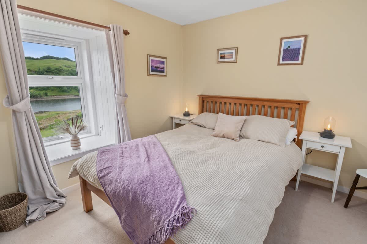 Cómodo dormitorio en la planta baja con gran ventana y vistas al lago y al jardín delantero