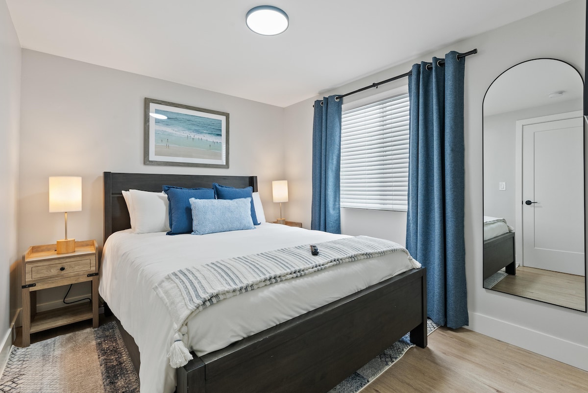 Este acogedor dormitorio queen está diseñado para la máxima relajación y conveniencia. Disfruta de la comodidad de una lujosa cama tamaño queen flanqueada por mesitas de noche dobles, perfectas para lo esencial de la noche. Diviértete con un televisor inteligente y mantén tu armario organizado en el armario. Empieza el día con una mirada al elegante espejo de cuerpo entero que refleja el ambiente sereno de tu retiro costero.