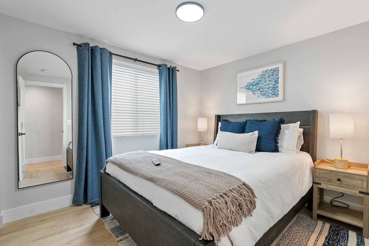 Este dormitorio azul de playa tamaño queen cuenta con mesitas de noche dobles para tu comodidad, un elegante televisor inteligente, un armario y un espejo de cuerpo entero. Sumérgete en la mezcla perfecta de encanto costero y comodidades modernas, lo que hace que cada estancia sea una escapada refrescante.