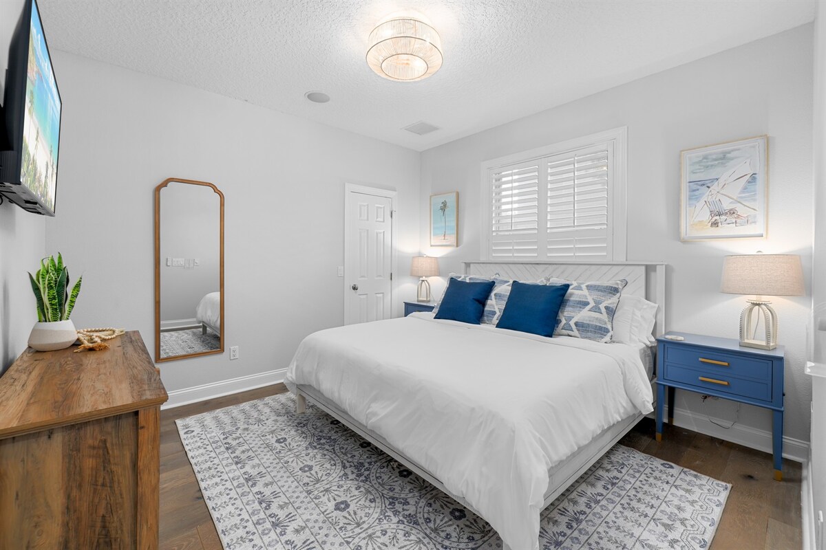 חדר אורחים מואר עם מיטת קינג סייז וטלוויזיה חכמה