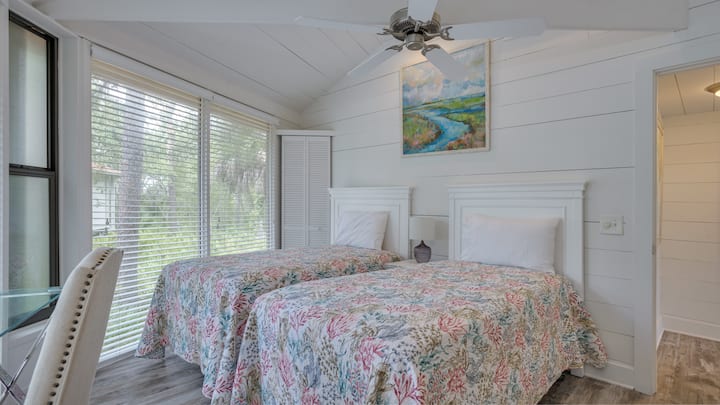 这间明亮的客房拥有舒适的海滨氛围，配有船形墙、拱形天花板和大窗户，可欣赏周围的棕榈景观。