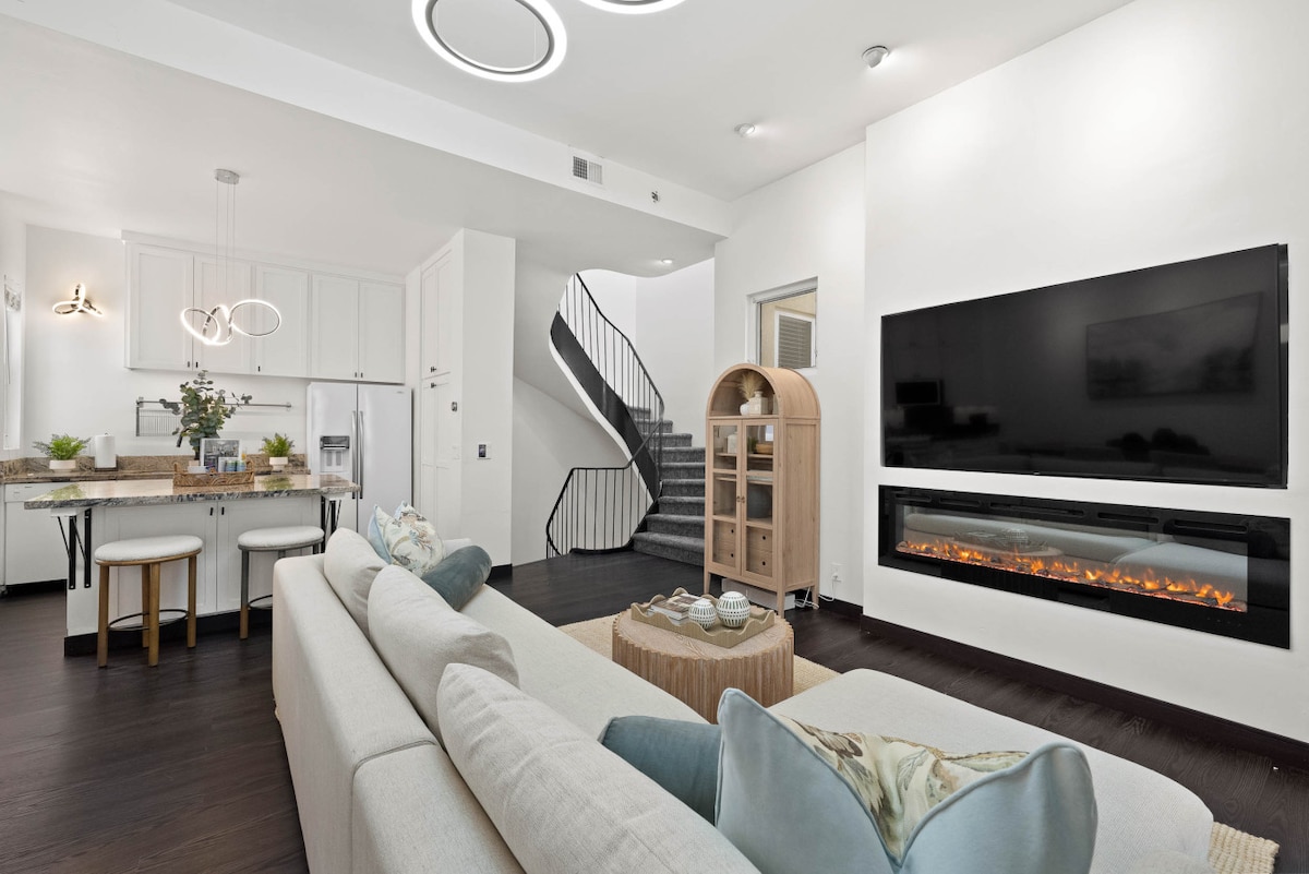 Elegante sala de estar con TV, lujosos asientos y un diseño luminoso y abierto para relajarse.