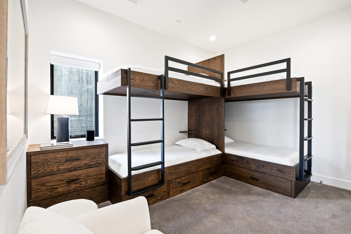 - غرفة نوم بأربعة أسرّة خشبية مدمجة بطابقين  
- سلالم وأدراج متينة للتخزين وسهولة الاستخدام  
- إعداد مثالي للأطفال أو الإقامات الجماعية معًا