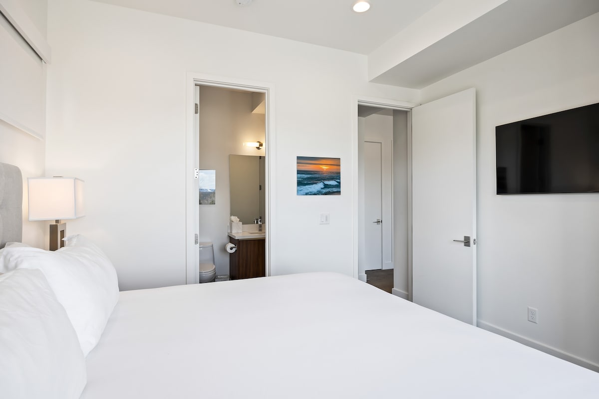 - غرفة نوم واسعة مع إمكانية الوصول إلى الحمام الداخلي  
- تلفزيون مثبت على الحائط وديكور أنيق للاسترخاء  
- مفروشات مريحة مع تصميم مشرق وجيد التهوية