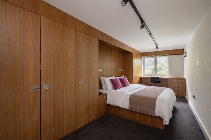 安静时尚的标准双人床卧室，配备定制木墙镶板、豪华标准双人床、高档床上用品、内置衣柜和柔和的自然光，营造出宁静、精致的休憩空间，是休息、舒适和不受打扰睡眠的理想场所。