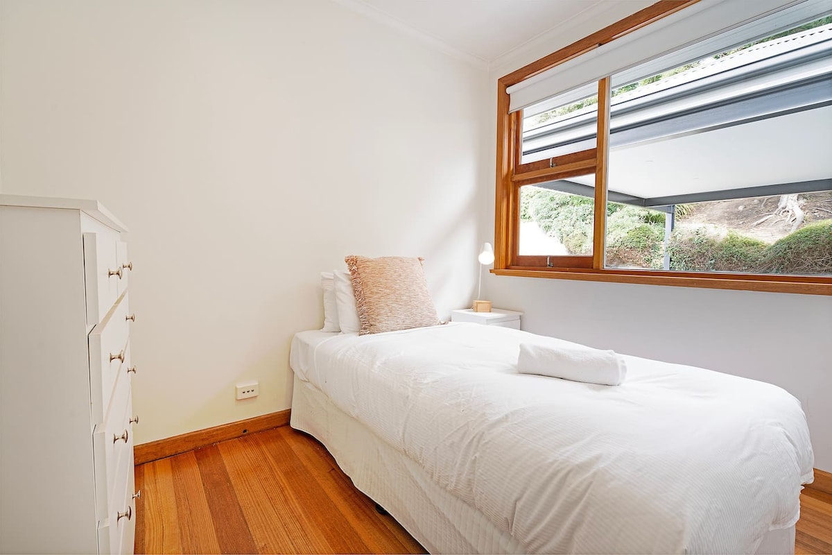 استرخ في غرفة النوم الثالثة بسرير كينج ومساحة واسعة لسرير أطفال، مما يجعلها مثالية للعائلات الشابة.