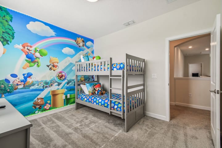 Cette chambre d'enfant joyeuse a une peinture murale des personnages de jeu préférés, créant une atmosphère amusante. Les lits superposés robustes avec une literie ludique promettent des nuits douillettes, tandis que le tapis moelleux offre un endroit confortable pour que les enfants jouent.