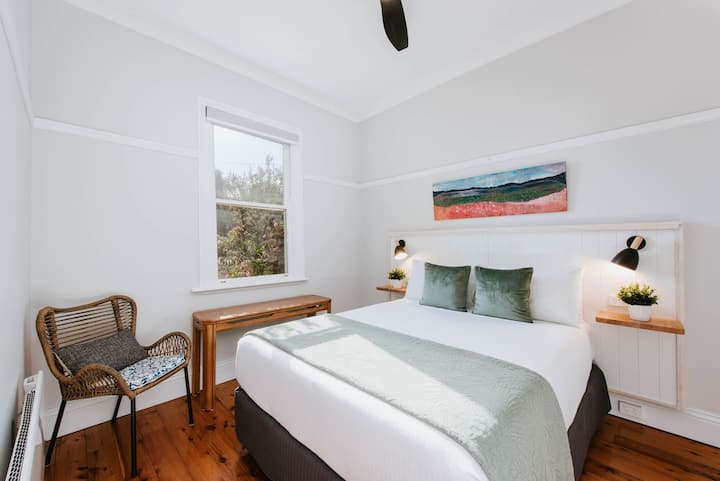 Utapata chumba cha nne cha kulala katika Nyumba ya shambani ya Kialla. Imewekwa na kitanda cha ukubwa wa malkia, meza za pembeni na taa za kusoma.
