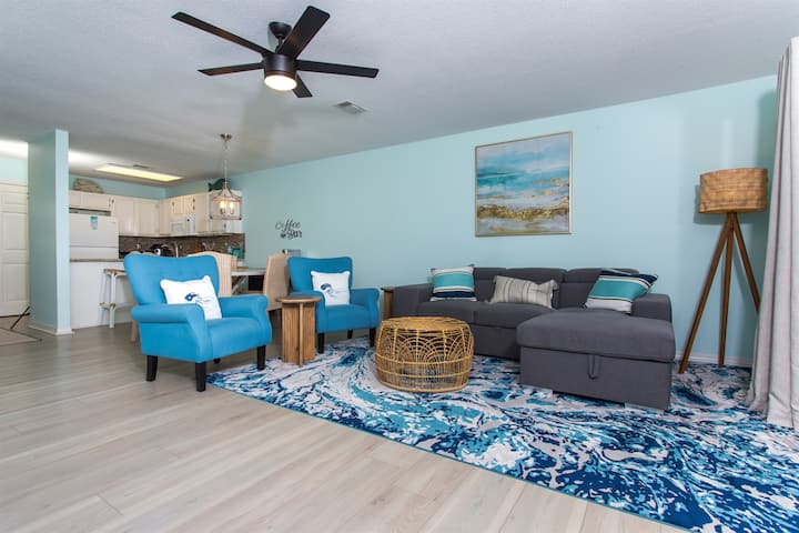 Táto otvorená obývacia izba a kuchyňa v dome na pláži sú príkladom dokonalej kombinácie funkčnosti, pohodlia a pobrežného šarmu.