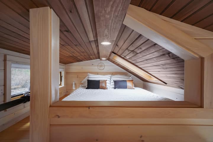 The bedroom loft with queen Casper mattress, accessible by stairs (not a ladder). And yes, the skylight has a shade to darken the room!