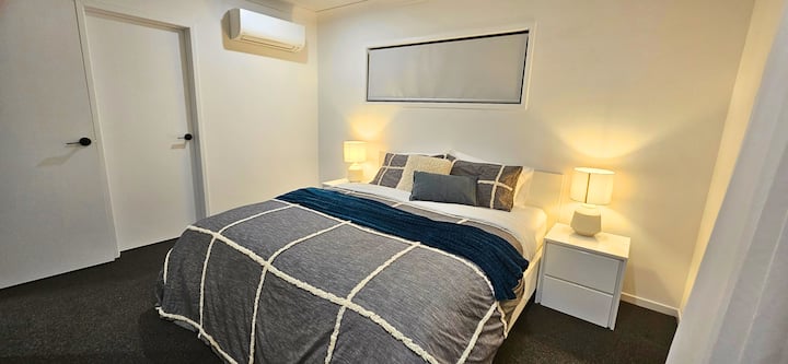 Საძინებელი 1-ში არის ორადგილიანი საწოლი საწოლთან მდგარი მაგიდებით, ლამპებით.