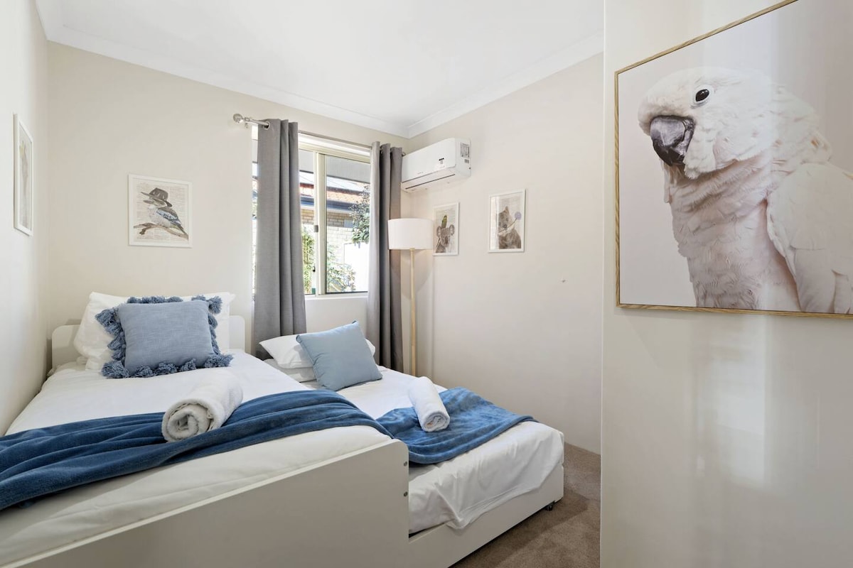 Habitación doble luminosa con sábanas suaves y luz natural.