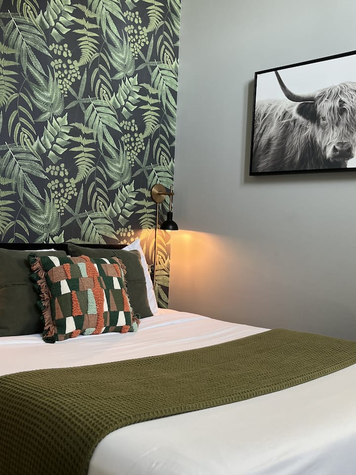 Sovrum med queen bed, smart-TV och tillgång till balkong