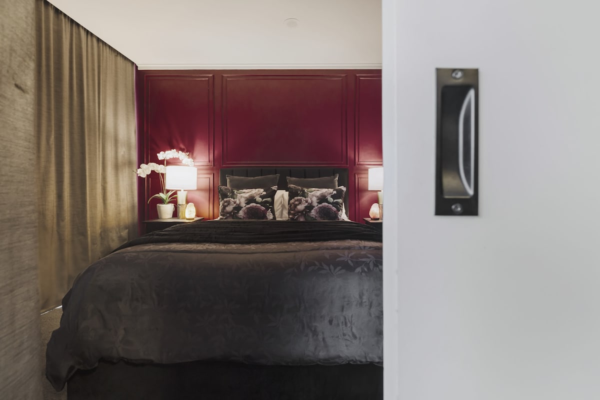 DORMITORIO: cama tamaño queen con ropa de cama de felpa, rodeada de tonos ricos y relajantes para una escapada serena