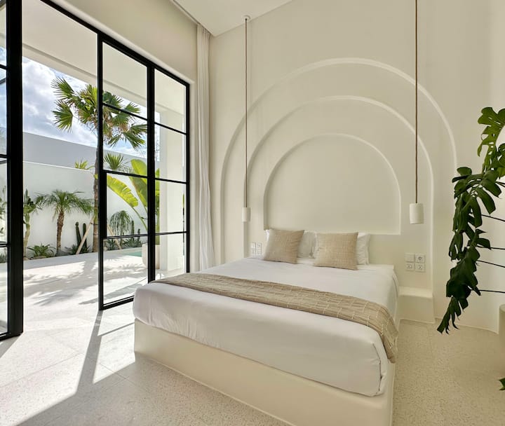 Designed for comfort, the bedroom includes a soft king-size bed, a large closet, and a private ensuite bathroom, blending modern elegance with natural warmth.