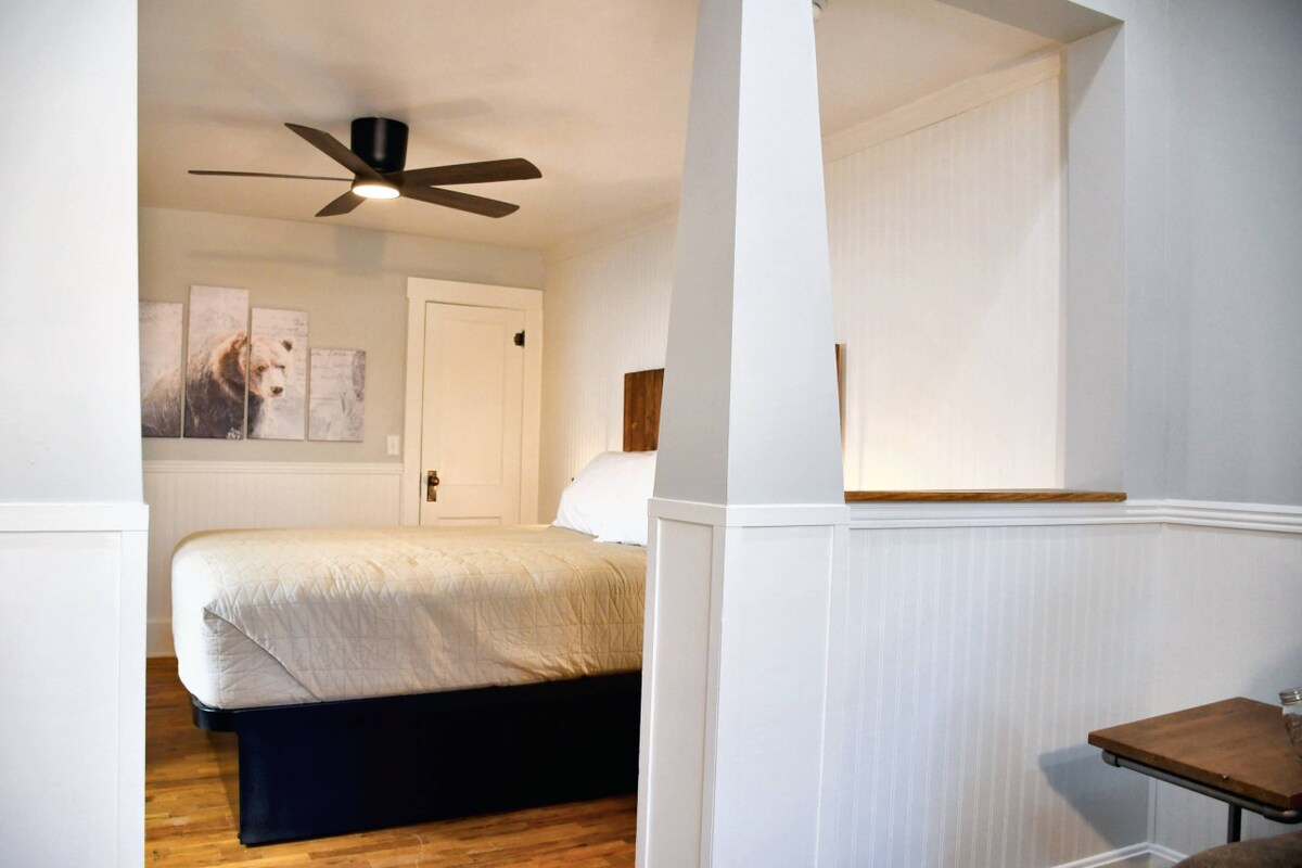 חדר שינה עם מחיצה פתוחה וייחודית המפרידה בין חדר השינה לסלון, ומוסיפה אופי לחלל.