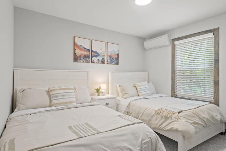 เตียงคู่ 2 หลังที่มีพื้นผิวนุ่มและแสงอบอุ่นทำให้ห้องนอนนี้เหมาะสำหรับทั้งเด็กและผู้ใหญ่