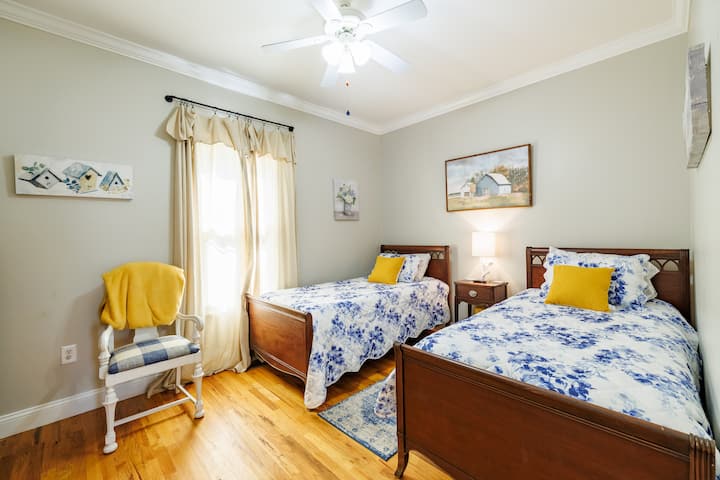 მზით განათებული ორადგილიანი საძინებელი, რომელიც გაფორმებულია ყვავილოვანი თეთრეულითა და მზისფერი აქცენტებით, იდეალურია მეგობრებისთვის, ბავშვებისთვის ან ნებისმიერი ადამიანისთვის, რომელიც მყუდრო გარემოში დასვენებას ელოდება.