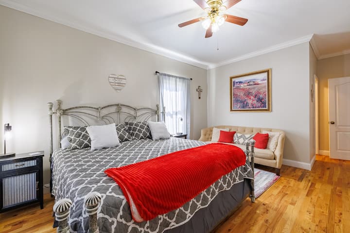 დიდი საძინებელი, რომელშიც დგას დივანი ელეგანტური დეტალებით — თქვენი პირადი თავშესაფარი დასასვენებლად, კომფორტისა და სტილისთვის.