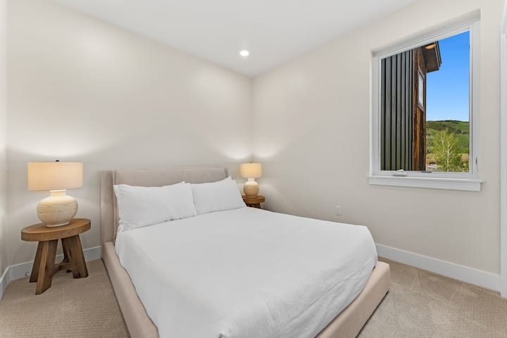 Dormitorio de invitados con cama tamaño queen y entrada privada al baño de invitados. 